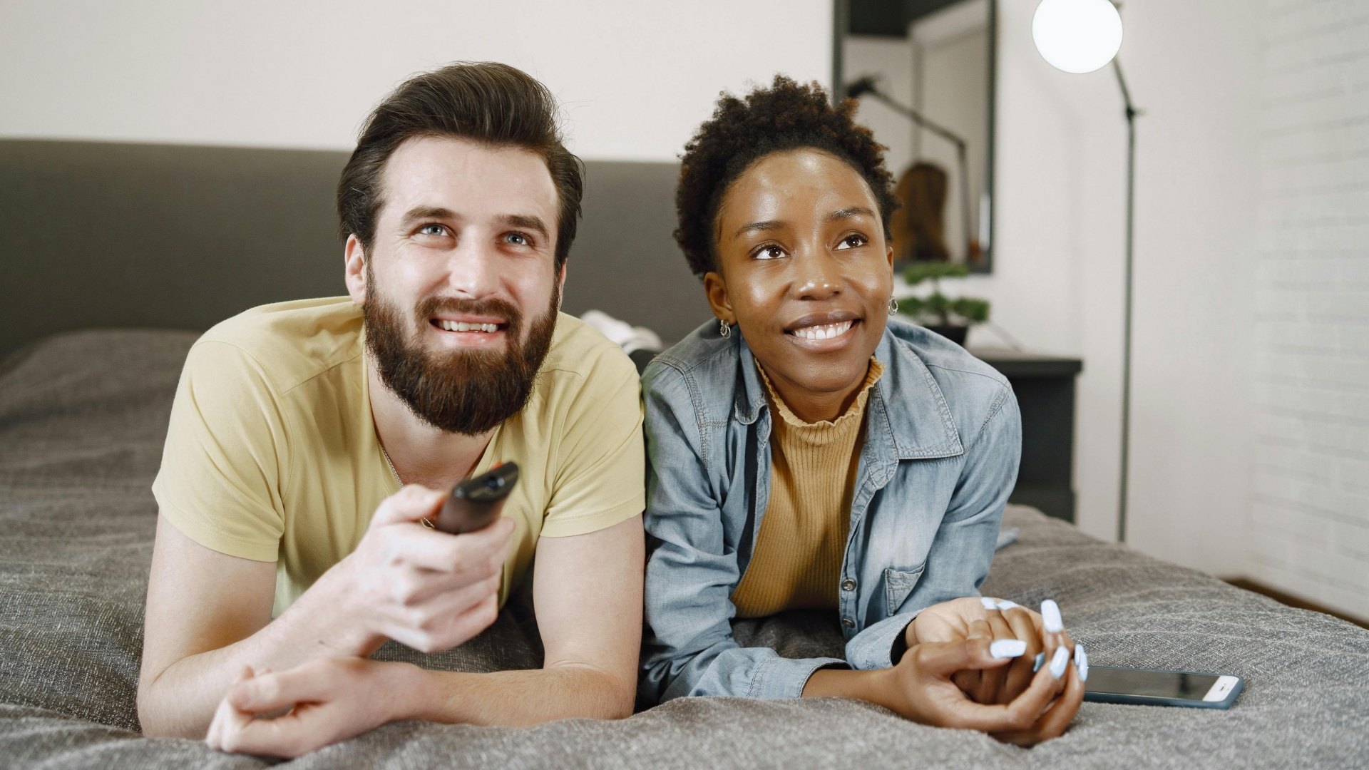 Casal assistindo televisão juntos em uma sala de estar aconchegante em casa.